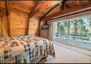 a bedroom with a bed and a large window at The Bears Lair Perfect for family w-full Amenities in Big Bear City