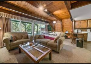a living room with two couches and a table at The Bears Lair Perfect for family w-full Amenities in Big Bear City