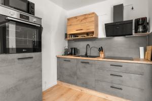 a kitchen with stainless steel cabinets and a sink at JUNEs - NEU mit Balkon, Grill, PS5, Bikekeller in Bad Berleburg +15 photos