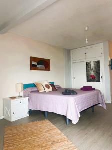 ein Schlafzimmer mit einem Bett mit einer lila Decke in der Unterkunft Apartamento con vistas al mar in Málaga