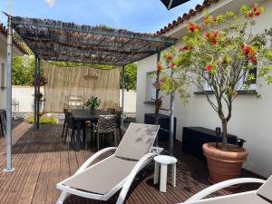 a patio with a table and chairs and a tree at Magnifique villa récente entre mer et montagne située entre Ajaccio et Porticcio in Cauro