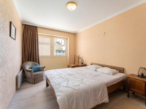 a bedroom with a bed and a chair and a window at ZAND III 0202 De Panne in De Panne