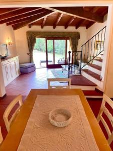 a dining room with a table and chairs and stairs at Villa Di Canio Piscina privata WiFi & Netflix in Cuile Pazzoni
