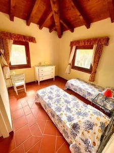 a bedroom with two beds and two windows at Villa Di Canio Piscina privata WiFi & Netflix in Cuile Pazzoni +27 photos