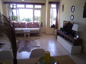 a living room with a couch and a tv at Mtwapa Cozy Apartment by Baharini in Mtwapa +7 photos