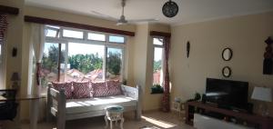 a living room with a couch and a large window at Mtwapa Cozy Apartment by Baharini in Mtwapa