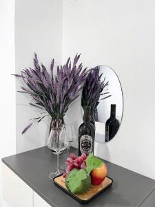 胡志明市Homey Haven Sư Vạn Hạnh的一张桌子,上面放着一盘水果和一瓶葡萄酒