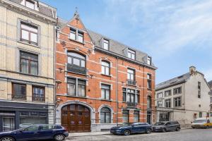 a brick building with cars parked in front of it at Loft City Center - 1 bedroom - parking - by FineNest in Liège +29 photos