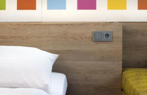 1 dormitorio con 1 cama y reloj en la pared en Business & Budget Hotel Tessin en Múnich