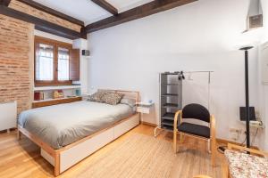 a bedroom with a bed and a desk and a chair at Judería Apartamento in Segovia