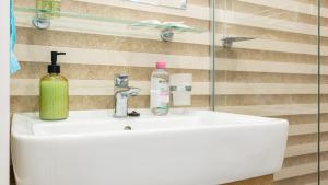 un lavabo con una botella de jabón verde. en SunShine Villa Brasov, en Brasov 55 fotos más