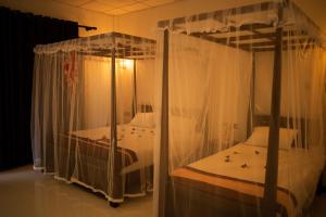 two bunk beds in a room with white curtains at Shine Park in Tissamaharama