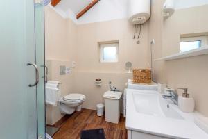 a white bathroom with a toilet and a sink at Apartment Island Oasis in Koločep +26 photos
