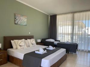 a hotel room with two beds and a large window at Centrum Rooms in Kallithea Halkidikis