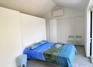 Un dormitorio con una cama en una habitación blanca. en La Rondinella ComoLake, en Argegno
