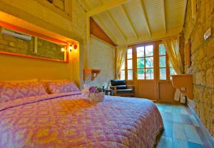 a bedroom with a bed with a purple comforter at Lilyum Alaçatı - Taş Ev in Alacati