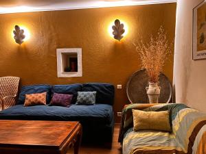 a living room with a blue couch and a table at Le Manou Maison de charme en Drôme provençale in Marsanne