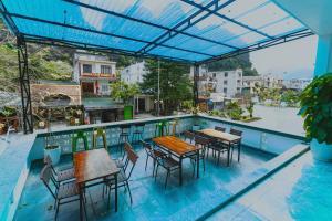 a patio with tables and chairs on a roof at Greenhouse in Phong Nha