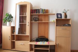 a wooden book shelf with a mirror in a room at Ferienwohnung Köhler in Goslar