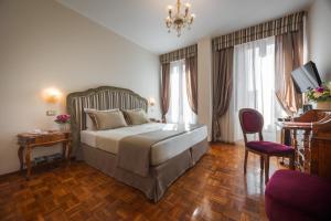 una camera da letto con un letto grande e una sedia di Hotel Forum a Roma