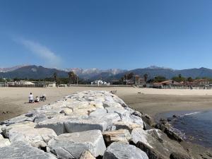 un groupe de personnes sur une plage avec des rochers dans l'établissement ISA- Holiday Home Il Pontile in Marina di Massa, apartments with private outdoor area, just 400 meters from the beach, à Marina di Massa