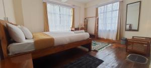 a bedroom with a large bed and a large window at Shree Niwas in Darjeeling