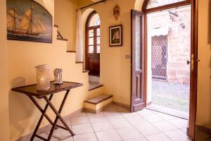 een hal met een houten tafel en een deur bij La Cambusa Apartment in Alghero