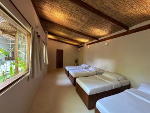 a room with three beds and a window at SEACLUB Siargao in General Luna +144 photos