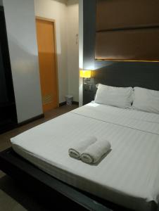 Postel nebo postele na pokoji v ubytování Lorenzzo Suites Hotel Makati
