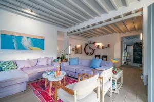a living room with a purple couch and a table at Villa in Kamares, Sifnos in Kamares