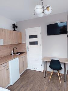 a kitchen with a table and a desk with a sink at Fundacja Apartamenty Czterolistna Koniczyna in Przemyśl +17 photos