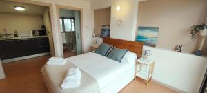 a bedroom with a white bed with blue pillows at Apartamento Loft Mar&Pol in Palafrugell