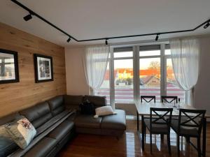 a living room with a couch and a table at Apartment Blue Green Virovitica in Virovitica +6 photos