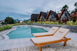 a resort with a pool and a lounge chair and a house at NATARASA Cottage in Ciwidey