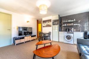 a living room with a couch a table and a kitchen at Les Lices A l Cozy & Central l Shellter Rentals in Saint-Tropez