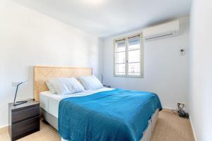 a bedroom with a large bed with a blue blanket at Les Lices A l Cozy & Central l Shellter Rentals in Saint-Tropez
