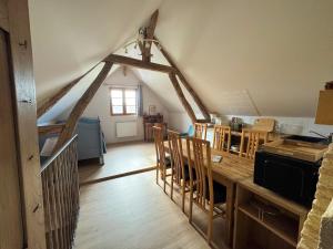a kitchen with a table and chairs in an attic at Gîte indépendant pouvant accueillir jusqu'à 6 personnes, situé dans une forêt in Saint-Parize-le-Châtel