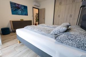 A bed or beds in a room at Jókai Apartman