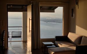 a living room with a couch and a large window at VergaView Luxury House in Kalamata +12 photos