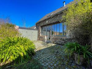 a brick house with a garage and a driveway at Ty Cosy-Charme et Confort au Coeur de la Bretagne in Plouézec