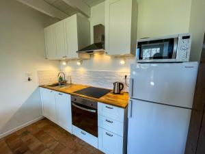 a kitchen with a white refrigerator and a microwave at Ty Cosy-Charme et Confort au Coeur de la Bretagne in Plouézec
