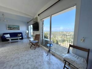 a living room with a large window and a couch at casa 7 pins in Begur