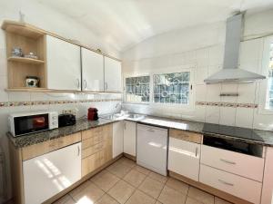 a large white kitchen with white cabinets and appliances at casa 7 pins in Begur