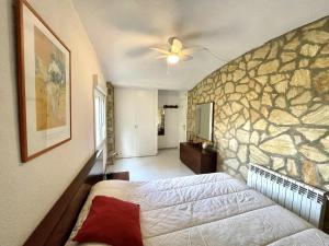 a bedroom with a bed and a stone wall at casa 7 pins in Begur