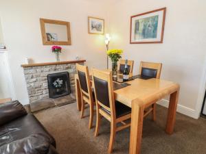 a dining room with a table and chairs and a fireplace at South View in Leyburn