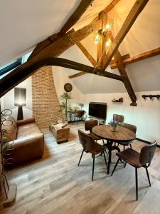 een woonkamer met een tafel en een bank bij L'Evidence, appartement authentique - Epernay in Épernay