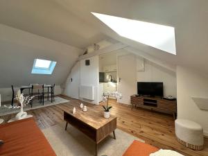 ein großes Wohnzimmer mit einem großen Oberlicht in einem Loft in der Unterkunft Studio cosy gare de St-Pierre-Des-Corps in Saint-Pierre-des-Corps + 3 Fotos