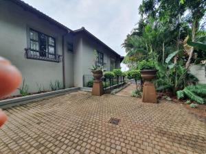 une maison avec deux plantes en pot devant elle dans l'établissement JV guesthouse, à Durban