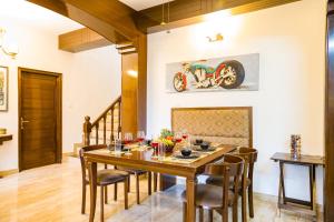 a dining room with a wooden table and chairs at Alaya Stays Kasauli Woods Cottage 3 BHK Retreat with Outdoor Lounge & Balcony in Patta