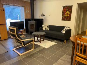 a living room with a couch and a tv at Kolbackens Camping & Stugby in Åsarne